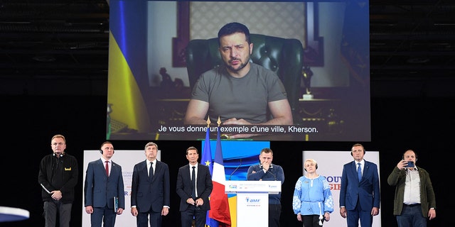 Ukrainian President Volodymyr Zelensky on a screen projection during the 104th session of the Congress of Mayors organised by "France's Mayors' Association" (AMF), in Paris, on November 22, 2022. 