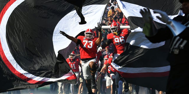 Georgia Bulldogs offensive lineman Xavier Truss (73) and defensive lineman Zion Logue (96) lead the team onto the field before a game against the Georgia Tech Yellow Jackets Nov. 26, 2022, at Sanford Stadium in Athens, Ga. 