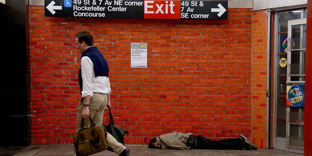 A homeless man sleeps inside a subway station in Midtown Manhattan. 