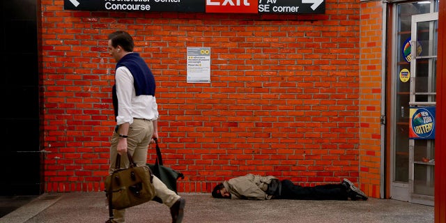 A homeless man sleeps inside a subway station in Midtown Manhattan.