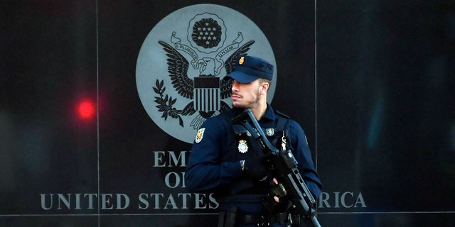 A Spanish policeman stands guard near the US embassy in Madrid, on December 1, 2022, after they have received a letter bomb, similar to one which went off at the Ukrainian embassy. 