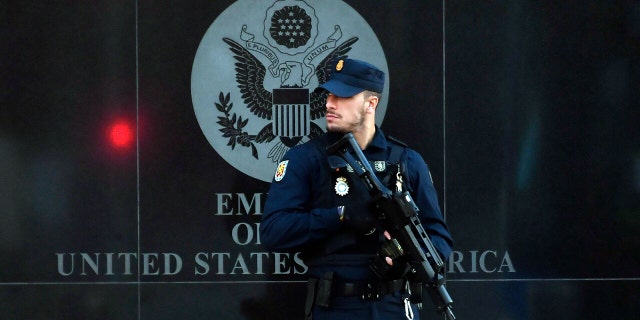 A Spanish policeman stands guard near the US embassy in Madrid, on December 1, 2022, after they have received a letter bomb, similar to one which went off at the Ukrainian embassy. 