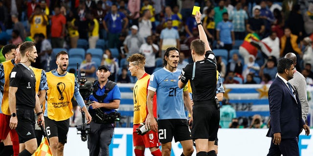 German referee Daniel Siebert presents a yellow card to Uruguay's forward Edinson Cavani after the end of the Qatar 2022 World Cup Group H match between Ghana and Uruguay at the Al-Janoub Stadium in Al-Wakrah, Qatar, on Friday.