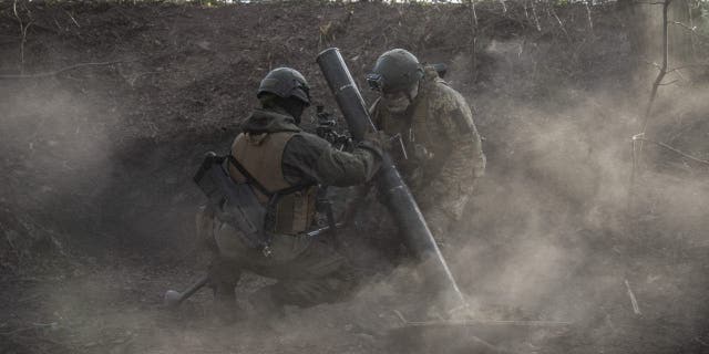 Soldados ucranianos assistem após disparar morteiros na linha de frente de Toritsk em Donbass, Ucrânia, em 2 de dezembro de 2022. 