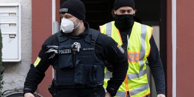 Police officers secure a searched property in Frankfurt, Germany, Dec. 7, 2022, during a raid against so-called "Reich citizens."