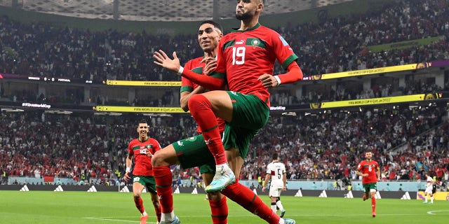 Morocco's forward #19 Youssef En-Nesyri celebrates with teammate Achraf Hakimi after scoring the opening goal against Portugal at the Al-Thumama Stadium in Doha on Dec. 10, 2022.