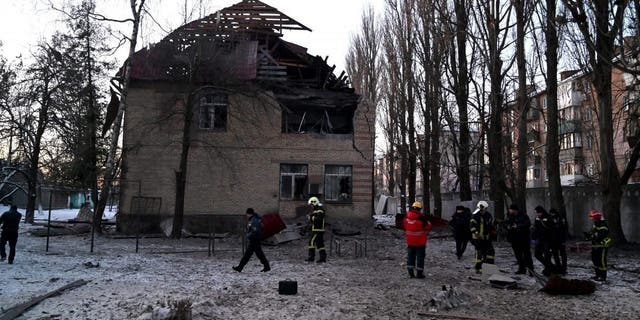 Rescuers and police experts examine remains of a drone following a strike on an administrative building in the Ukrainian capital Kyiv on Dec. 14, 2022. 