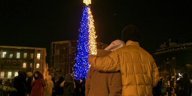 People take photos the Christmas tree at the Sofiyska Square after a massive russian drones attack on Ukrainian power infrastructure early morning in Kyiv, Ukraine, Dec. 19, 2022.