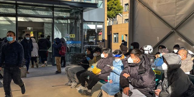 People wait for medical attention at Fever Clinic area in Tongren Hospital in the Changning district in Shanghai, on December 23, 2022 - China is battling a wave of coronavirus infections that has hit the elderly hard but resulted in only a handful of reported deaths after the government redefined the criteria by which Covid-19 fatalities are counted. 