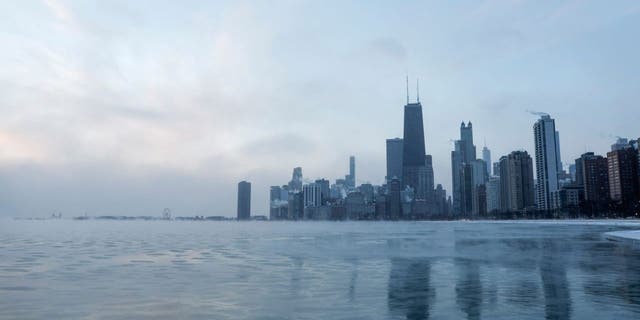 Mist rises from Chicago and Lake Michigan at sunrise on December 23, 2022, where temperatures reached -6F (-21C), ahead of the Christmas Holiday. - A "once-in-a-generation" winter storm with temperatures as low as -40F (-40C) caused Christmas travel chaos in the US on December 22, 2022, with thousands of flights cancelled and major highways closed. (Photo by KAMIL KRZACZYNSKI / AFP) 