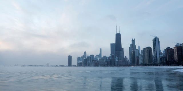 Mist rises from Chicago and Lake Michigan at sunrise on December 23, 2022, where temperatures reached -6F (-21C), ahead of the Christmas Holiday. - A "once-in-a-generation" winter storm with temperatures as low as -40F (-40C) caused Christmas travel chaos in the US on December 22, 2022, with thousands of flights cancelled and major highways closed. (Photo by KAMIL KRZACZYNSKI / AFP) 