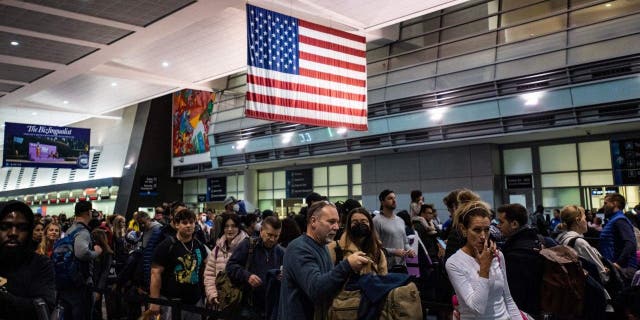 Travelers make their way through a security line at Logan International Airport in Boston, Massachusetts, on December 23, 2022. - A historic and brutal winter storm put some 240 million Americans under severe weather warnings Friday as the US faced holiday travel chaos, with thousands of flights cancelled and major highways closed. (Photo by Joseph Prezioso / AFP) (Photo by JOSEPH PREZIOSO/AFP via Getty Images)