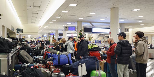 Stranded Southwest Airlines passengers looks for their luggage in the baggage claim area at Chicago Midway International Airport in Chicago, Illinois, on December 28, 2022. 