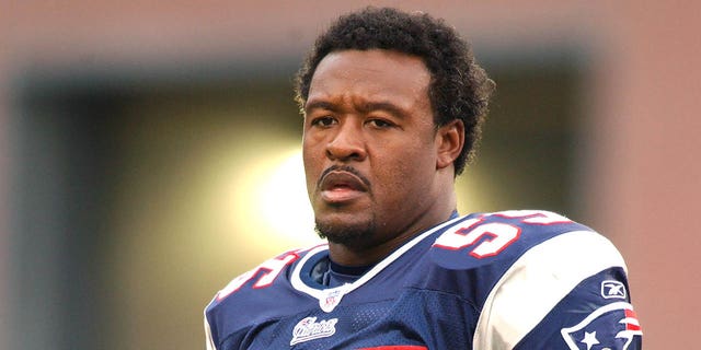 Willie McGinest #55 of the New England Patriots looks on before an NFL football game against the Miami Dolphins on October 10, 2004, at Gillette Stadium in Foxborough, Massachusetts.  