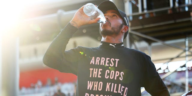 Lewis Hamilton of Great Britain and Mercedes GP wears a T-shirt displaying the message "Arrest the cops who killed Breonna Taylor" as he celebrates victory after the F1 Grand Prix of Tuscany at Mugello Circuit Sept. 13, 2020 in Scarperia, Italy. 