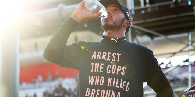 Lewis Hamilton of Great Britain and Mercedes GP wears a T-shirt displaying the message "Arrest the cops who killed Breonna Taylor" as he celebrates victory after the F1 Grand Prix of Tuscany at Mugello Circuit Sept. 13, 2020 in Scarperia, Italy.