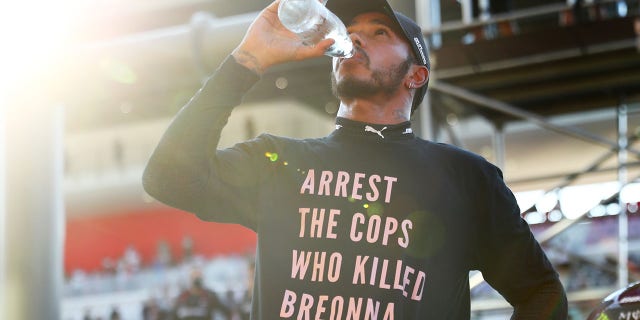 Lewis Hamilton de Gran Bretaña y Mercedes GP usan una camiseta que muestra el mensaje "Arrestar a los policías que mataron a Breonna Taylor" mientras celebra la victoria después del Gran Premio de F1 de la Toscana en el circuito de Mugello el 13 de septiembre de 2020 en Scarperia, Italia. 