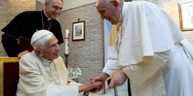 Pope Francis greets Pope Emeritus Benedict XVI during a meeting with newly named Cardinals at the Vatican's Mater Ecclesiae Monastery on Aug. 27, 2022, in Vatican City.