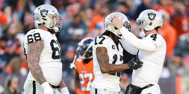 Davante Adams (17) of the Las Vegas Raiders celebrates with Derek Carr (4) after catching a pass for a touchdown during a game against the Denver Broncos at Empower Field at Mile High on November 20, 2022 in Denver, Colorado .