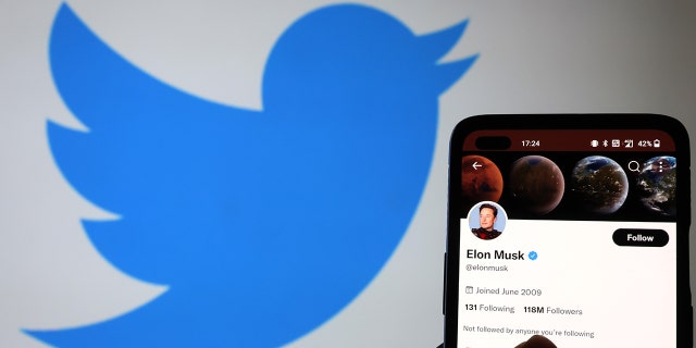 The Twitter account of Elon Musk is displayed on a smartphone with a Twitter logo in the background on November 21, 2022 in Newcastle Under Lyme, England.