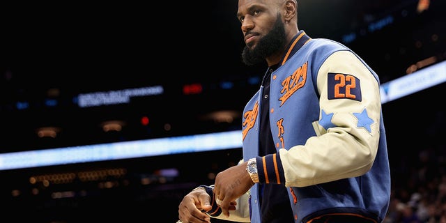 LeBron James, #6 of the Los Angeles Lakers, watches from the sidelines during the first half of the NBA game against the Phoenix Suns at Footprint Center on November 22, 2022, in Phoenix, Arizona. 