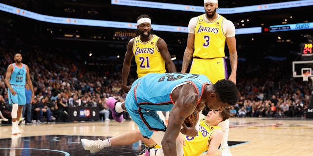 Deandre Ayton, #22 of the Phoenix Suns, falls on Austin Reaves, #15 of the Los Angles Lakers, after being pushed by Patrick Beverley, #21, during the second half of an NBA game at the Footprint Center on November 22 2022 in Phoenix.  Beverley was ejected on the play.  The Suns defeated the Lakers 115-105.  