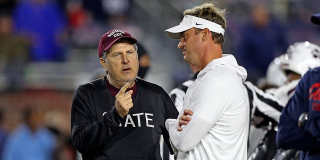 Mike Leach of the Bulldogs and Lane Kiffin of the Rebels talk before the game at Vaught-Hemingway Stadium on Nov. 24, 2022, in Oxford, Mississippi.