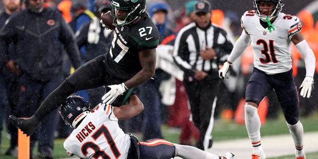Zonovan Knight (27) of the New York Jets jumps over Elijah Hicks (37) of the Chicago Bears in the second half of a game at MetLife Stadium on November 27, 2022 in East Rutherford, NJ 