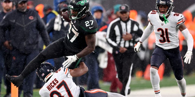 Zonovan Knight (27) of the New York Jets leaps over Elijah Hicks (37) of the Chicago Bears in the second half of a game at MetLife Stadium Nov. 27, 2022, in East Rutherford, N.J.