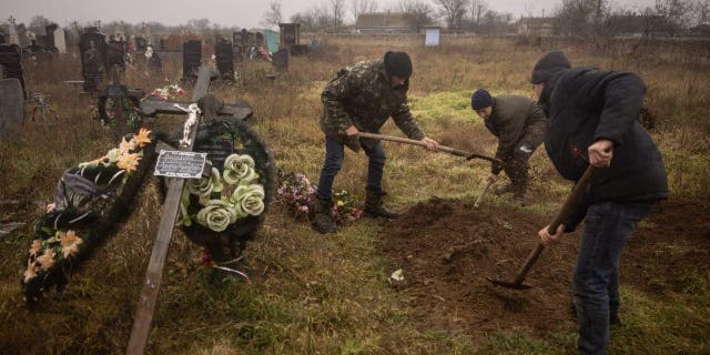 Ukrainische Einwohner und Behörden exhumieren die Leichen eines 16-jährigen Mädchens und sieben Jungen, die am 29. November 2022 in der Stadt Pravdyn, einem Vorort von Cherson, von russischen Streitkräften getötet wurden.