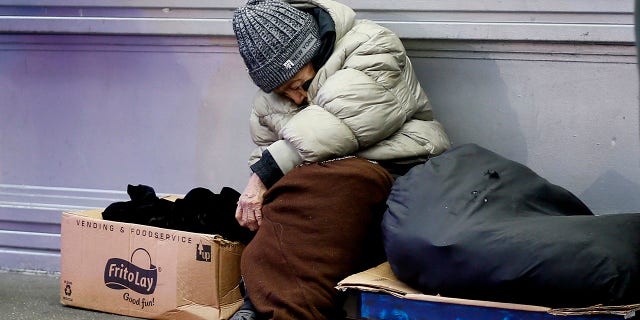 A homeless person sits in the street on November 30, 2022 in New York City.