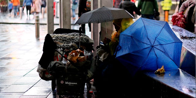 A homeless person sits at Times Square on November 30, 2022 in New York City. 