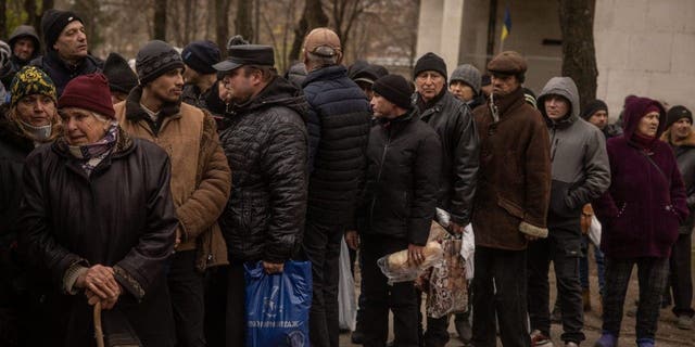 Residents wait to receive humanitarian aid in Kherson city center on Dec. 1, 2022, in Kherson, Ukraine.