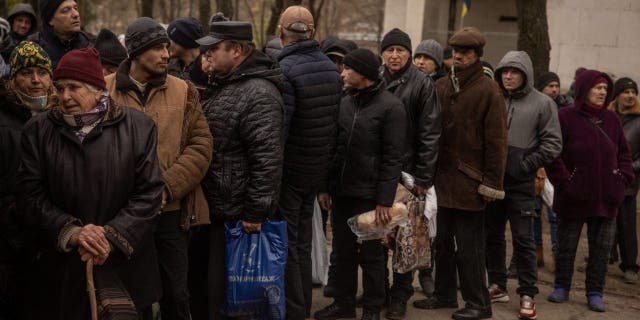 Residents wait to receive humanitarian aid in Kherson city center on Dec. 1, 2022, in Kherson, Ukraine.