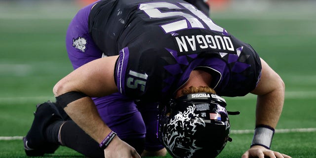 Quarterback Max Duggan of the TCU Horned Frogs reacts after being hit after a pass in the second half against the Kansas State Wildcats on December 3, 2022, in Arlington, Texas.