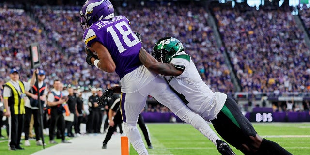 Justin Jefferson, #18 of the Minnesota Vikings, catches a touchdown pass while D.J. Reed, #4 of the New York Jets, defends during the fourth quarter at U.S. Bank Stadium on Dec. 4, 2022 in Minneapolis.