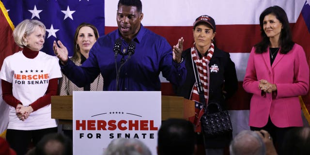 Georgia Republican Senate nominee Herschel Walker speaks as (L-R) Republican National Committeewoman for Georgia Ginger Howard, Republican National Committee Chair Ronna McDaniel, Walker’s wife Julie Blanchard and former U.S. Ambassador to the U.N. Nikki Haley listen during a campaign rally on December 5, 2022 in Kennesaw, Georgia.