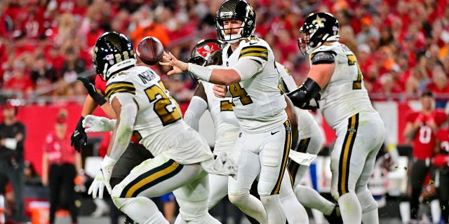 Andy Dalton (14) of the New Orleans Saints flicks the ball to Mark Ingram II (22) against the Tampa Bay Buccaneers during the third quarter of a game at Raymond James Stadium Dec. 5, 2022, in Tampa, Fla. 