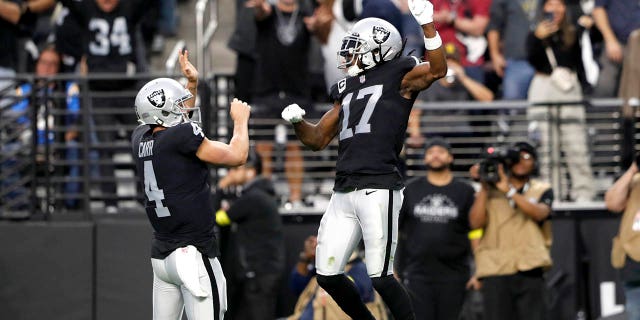 Wide receiver Davante Adams (17) of the Las Vegas Raiders celebrates with quarterback Derek Carr (4) after scoring a touchdown in the third quarter against the Los Angeles Chargers at Allegiant Stadium Dec. 4, 2022, in Las Vegas. 