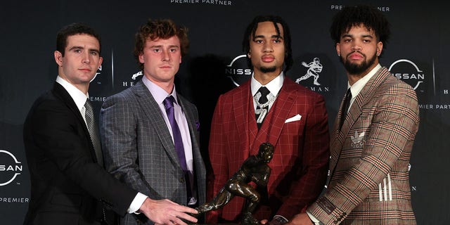 (L-R) Quarterback Stetson Bennett of the Georgia Bulldogs, Quarterback Max Duggan of the TCU Horned Frogs, Quarterback C.J. Stroud of the Ohio State Buckeyes and Quarterback Caleb Williams of the USC Trojans pose with the Heisman Trophy after a press conference prior to the 2022 Heisman Trophy Presentation at New York Marriott Marquis Hotel on December 10, 2022, in New York City. 