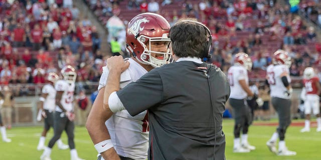 Gardner Minshew, left, of the Washington State Cougars, confers with head coach Mike Leach during an NCAA Pac-12 college football game against the Stanford Cardinal Oct. 27, 2018, at Stanford Stadium in Palo Alto, Calif.  