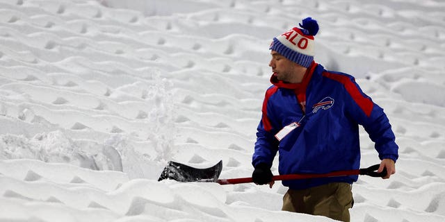 Stadium workers clear snow off the field prior to a game between the Miami Dolphins and Buffalo Bills at Highmark Stadium on Dec. 17, 2022 in Orchard Park, New York. 