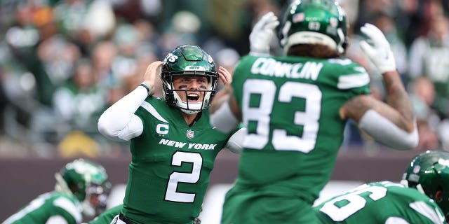 Zach Wilson points to the offensive line in a game against the Lions