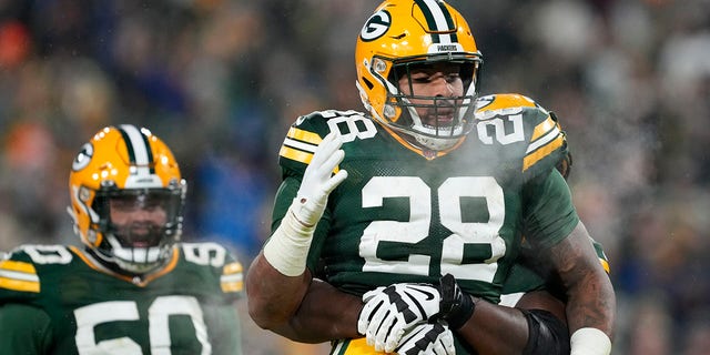 #28 AJ Dillon de los Green Bay Packers reacciona después de un touchdown contra Los Angeles Rams en Lambeau Field el 19 de diciembre de 2022 en Green Bay, Wisconsin. 