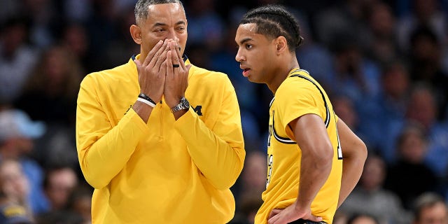 Michigan Wolverines head coach Juwan Howard talks with Jett Howard during the second half of a game against the North Carolina Tar Heels at the Spectrum Center in Charlotte, North Carolina, on Wednesday.