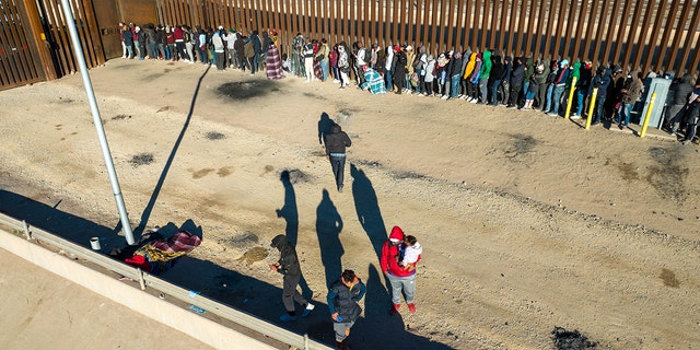 An aerial view of immigrants lining up next to the U.S.-Mexico border fence after spending the night outside on December 22, 2022 in El Paso, Texas. 
