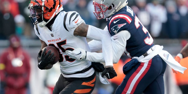 FOXBOROUGH, MASSACHUSETTS - DECEMBER 24: Jonathan Jones #31 of the New England Patriots attempts to tackle Tee Higgins #85 of the Cincinnati Bengals during the third quarter at Gillette Stadium on December 24, 2022, in Foxborough, Massachusetts.