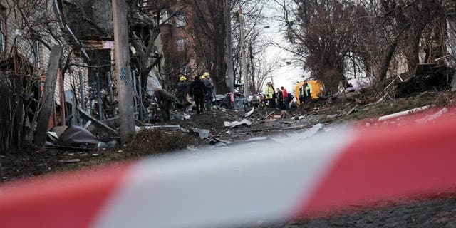 Emergency workers gather at the scene of a blast on New Year’s Eve, Dec. 31, 2022 in Kyiv, Ukraine.
