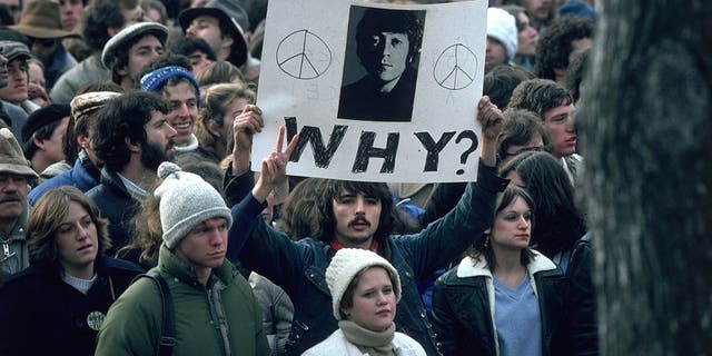 December 1980: Fans of John Lennon hold a vigil after he was shot dead by a fan on December 8th at his home in New York City.  