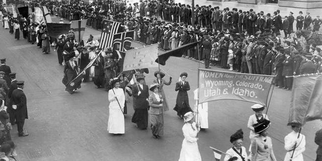 Suffragettes carry a banner announcing that "women have the right to vote in Wyoming, Colorado, Utah and Idaho" during the parade of women of all nations in New York on May 3, 1916.